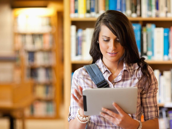 Female student in library working on tablet
