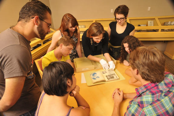 A group of students and instructor examining an artifact