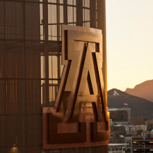 UA symbol on the side of a building with the A Mountain in the background